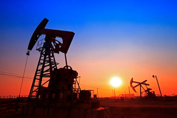 tempo do sol da bomba de óleo, equipamentos de indústria de petróleo - oil pumping unit at sunset time - fotografias e filmes do acervo