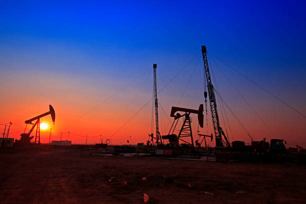 tempo do sol da bomba de óleo, equipamentos de indústria de petróleo - oil pumping unit at sunset time - fotografias e filmes do acervo