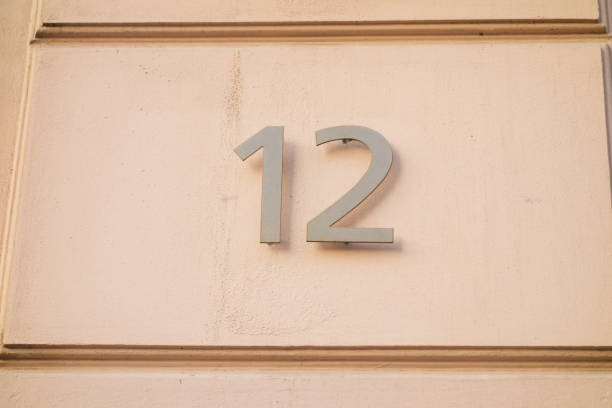 istock number 12 door sign on orange facade 867642060
