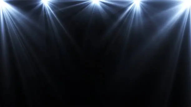 Photo of spotlights lighting flare on a dark background, abstract