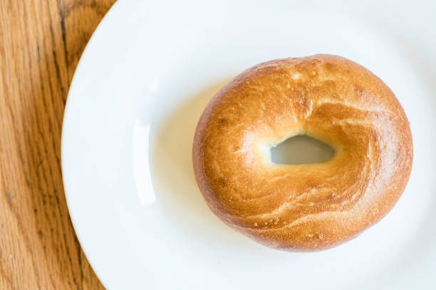 白い皿、木にプレーンのベーグル - bagel bread isolated circle ストックフォトと画像