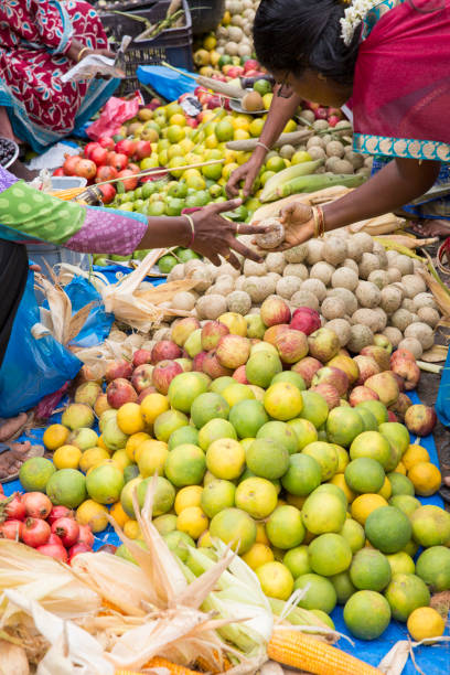 PONDICHERY, PUDUCHERY, INDIA - SEPTEMBER 09, 2017. Unidentified man woman at his fruit and or vegetables shop in the main market of the city, in south of India, Asia.