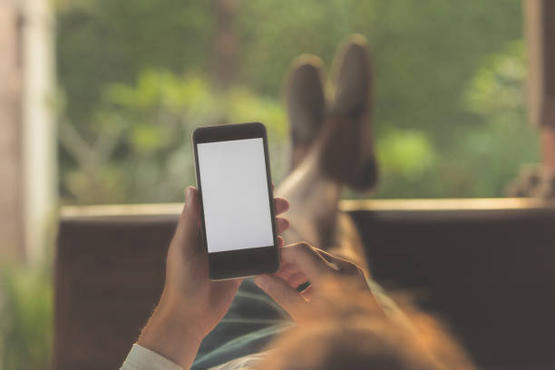 Man lying on a sofa and using cellphone. Man lying on a sofa and using cellphone. legs crossed at ankle stock pictures, royalty-free photos & images