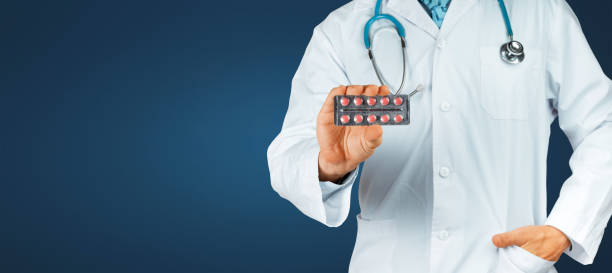 This Will Help. Doctor Holding Blisters With Red Pills, Close-up stock photo