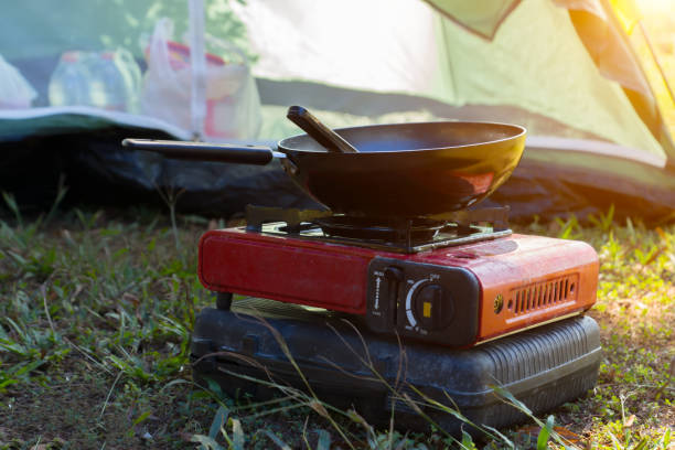 Portable gas stove and a frying pan in the camp. Portable gas stove and a frying pan in the camp with sunlight. stove stock pictures, royalty-free photos & images