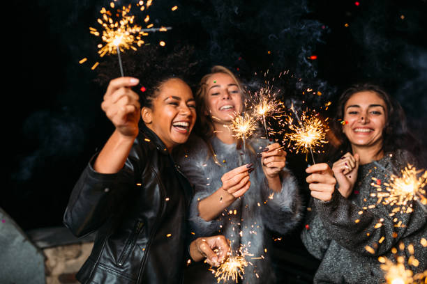 istock Young friends enjoying with sparklers at night 867679998