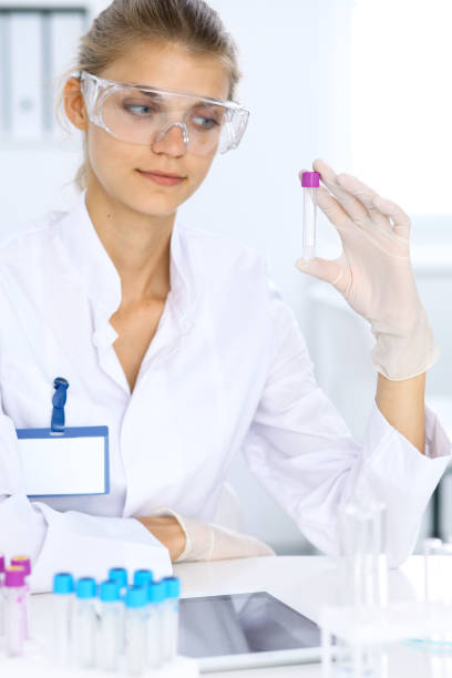 female scientific researcher in laboratory studying substances or blood sample. medicine and science concept - close up medical test exam people imagens e fotografias de stock