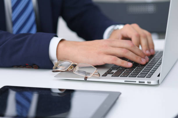 istock Businessman working by typing on laptop computer. Man's hands on notebook or business person at workplace. Employment  or start-up concept 867682466