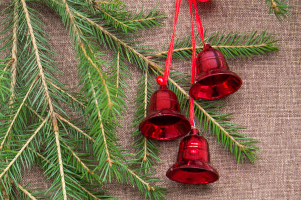 istock Christmas background with green spruce branches and red bells. Top view. 867685976