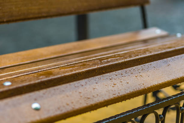 Water drops on the orange colored bench. Close up