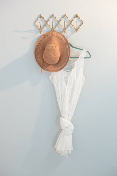 istock Hat and dress hanging against white wall 867689314