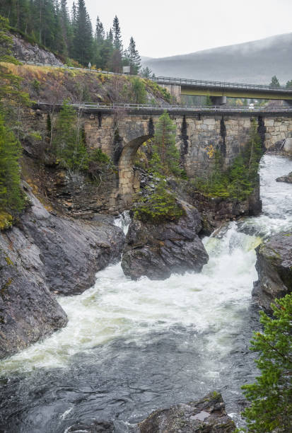 istock A beautiful historic stone bridge crossing the river in central Norway. 867692912