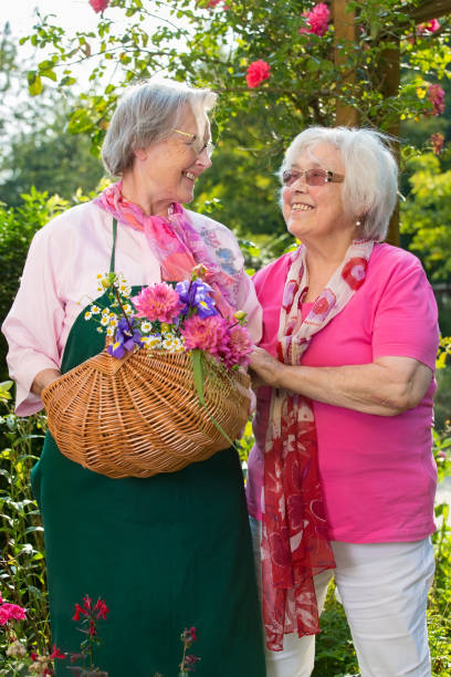 istock Two senior women with basket standing in garden. 867695992