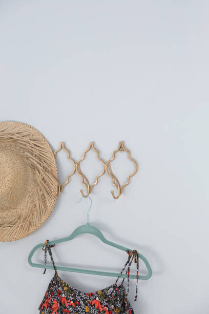 istock Hat and dress hanging against white wall 867696152