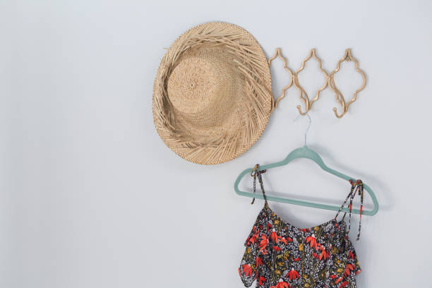 istock Hat and dress hanging against white wall 867696166