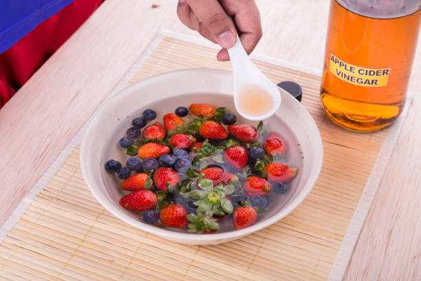 アップル サイダーの酢は、果物や野菜は、農薬を中和します。 - washing fruit preparing food strawberry ストックフォトと画像