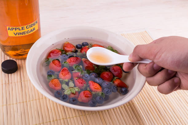 アップル サイダーの酢は、果物や野菜は、農薬を中和します。 - washing fruit preparing food strawberry ストックフォトと画像