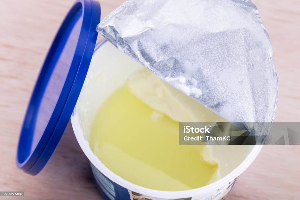 Layer of whey protein formed on top of packaged yogurt Layer of whey protein formed on top of packaged yogurt after opening.  It had not turned bad. Obsolete Stock Photo