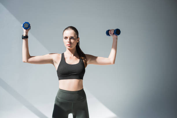 istock athletic girl with dumbbells 867700338