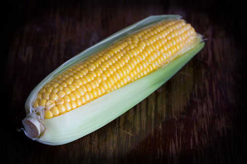 Fresh, Sweet Yellow corn on cobs on rustic wooden table, close up background.