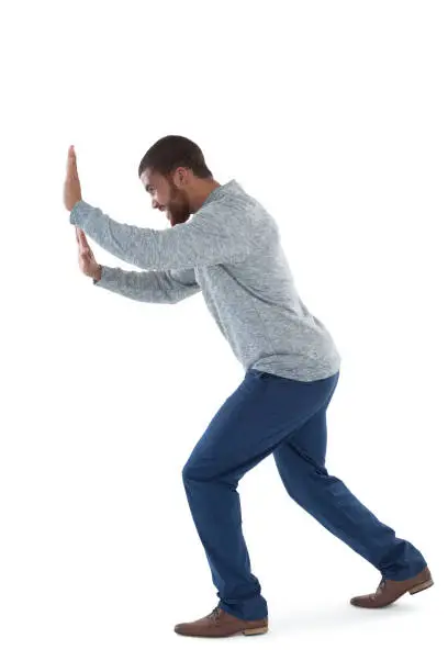 Young male executive pushing the side against white background