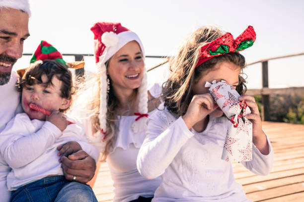 little girl peers into christmas cracker looking for more - christmas child little boys peeking imagens e fotografias de stock