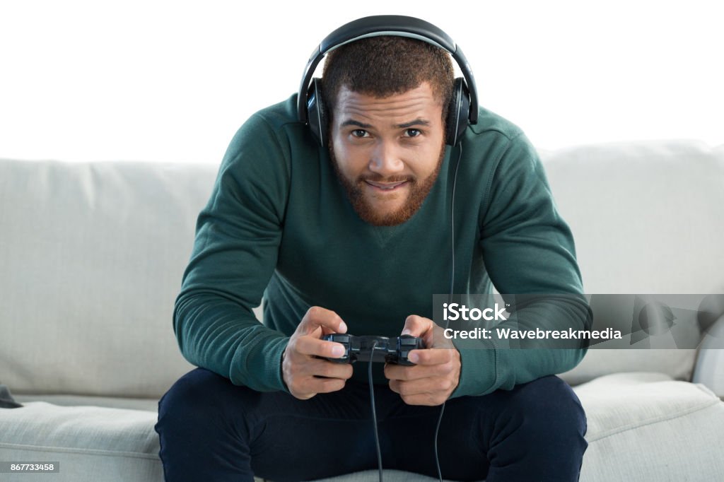 Man playing video game against white background Smiling man playing video game against white background Video Game Stock Photo