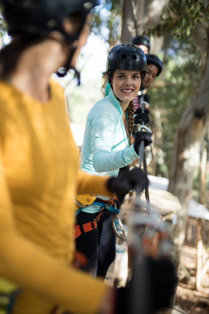 istock Friends enjoying zip line adventure in park 867739368