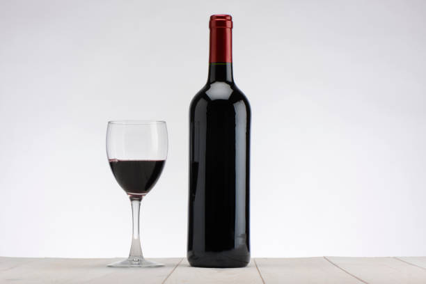 Shot of a red wine bottle on a vignetted colour background that has been extended to add extra copy space for the designer