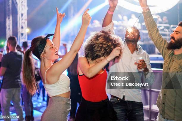 Young Friends Dancing In Night Club Festival Event Party With Dj In Background Happy People Having Fun Inside Disco Nightlife Concept Unfiltered Photo With Soft Focus On Left Girl Face Stock Photo - Download Image Now