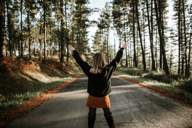 istock Young woman with arms raised at forest 867747062