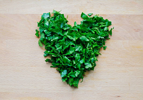 Heart shape of green parsley on wooden background
