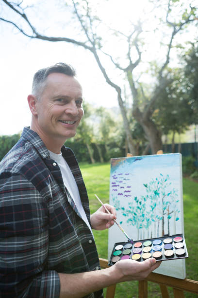 istock Man painting on canvas in garden 867758798