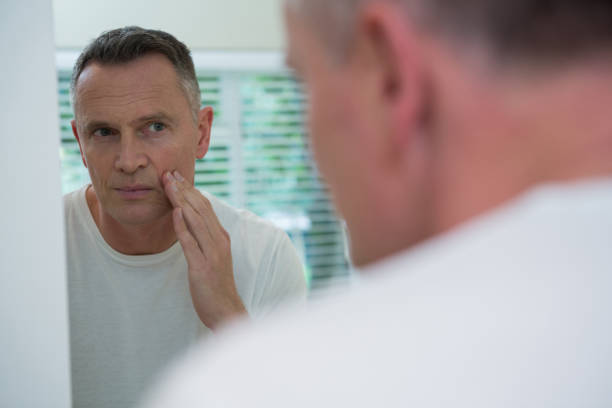 istock Man looking his face in the mirror after shaving 867761386