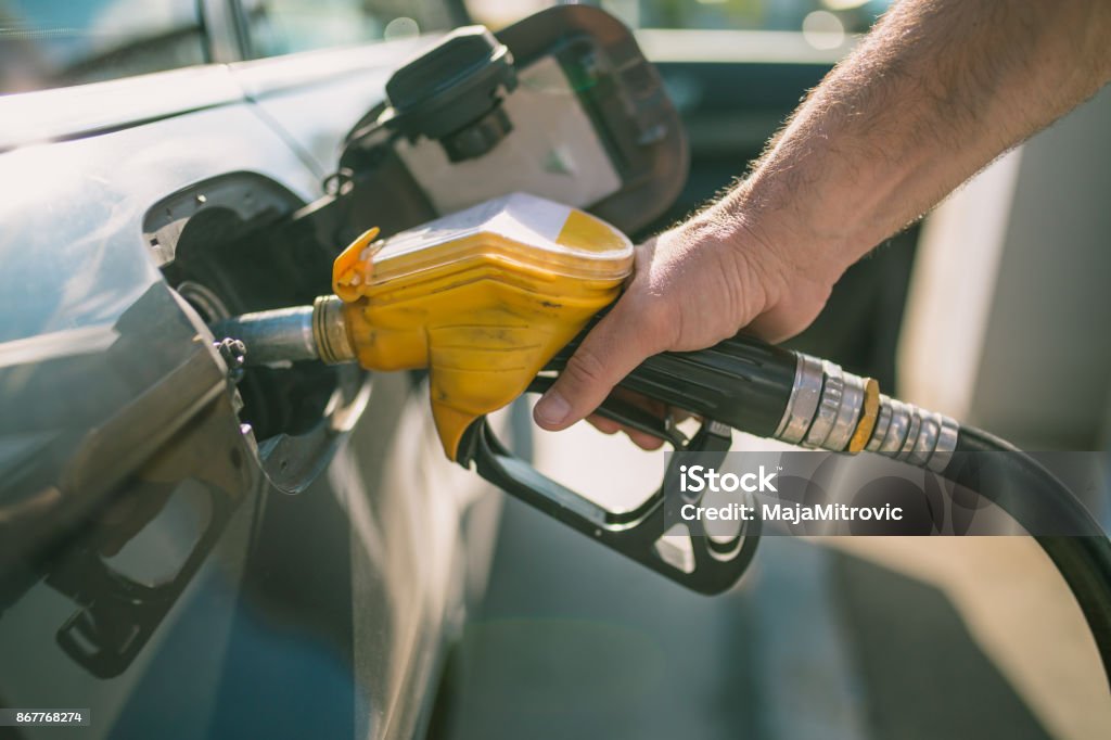 Car refueling on petrol station. Man pumping gasoline oil. This photo can be used for automotive industry or transportation concept Fuel Pump Stock Photo