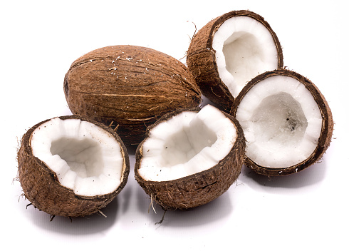 One whole coconut and four halves isolated on white background