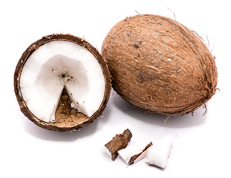 One whole coconut, one half and meat pieces isolated on white background