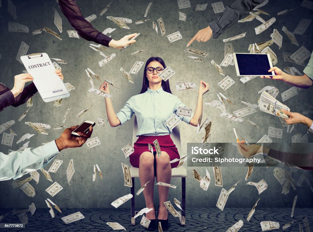 Young business woman is meditating to relieve stress of busy corporate life under money rain Emotional Stress Stock Photo