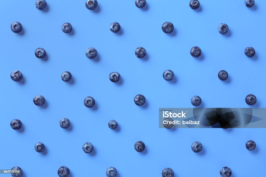 Colorful pattern of blueberries Colorful pattern of blueberries on blue background. From top view Blueberry Stock Photo