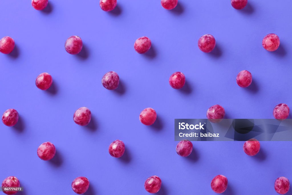 Colorful pattern of grapes Colorful pattern of grapes on purple background. From top view Grape Stock Photo