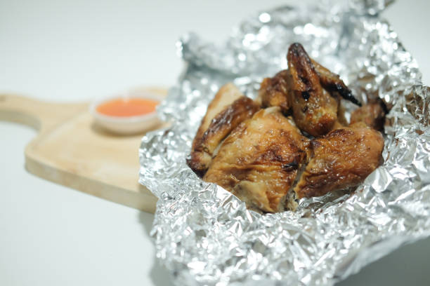 istock Chicken with sauce in foil on wooden tray 867774318
