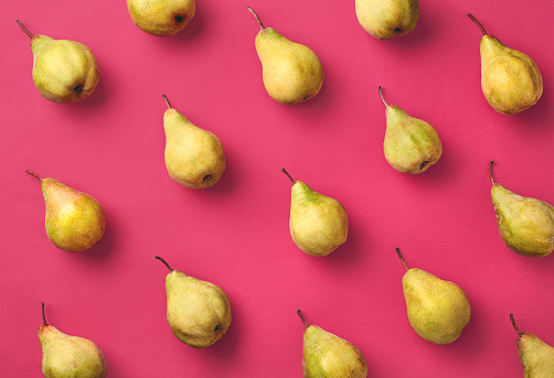 Colorful fruit pattern of fresh pears on pink background. From top view