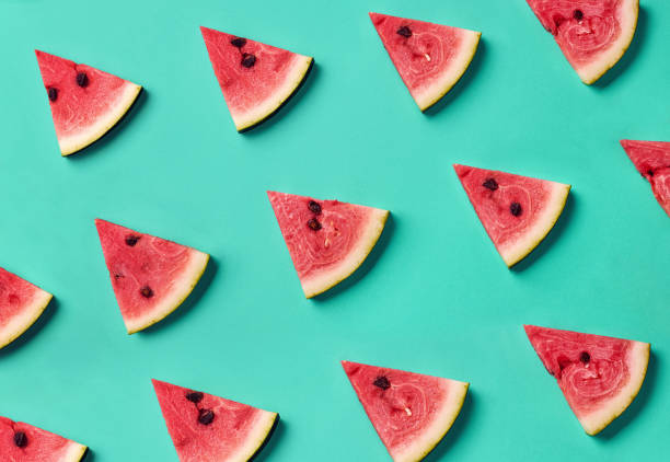 Colorful pattern of watermelon slices Colorful fruit pattern of fresh watermelon slices on blue background. From top view melon photos stock pictures, royalty-free photos & images