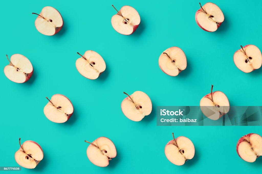 Colorful pattern of apples Colorful fruit pattern of fresh apple halves on blue background. From top view Fruit Stock Photo