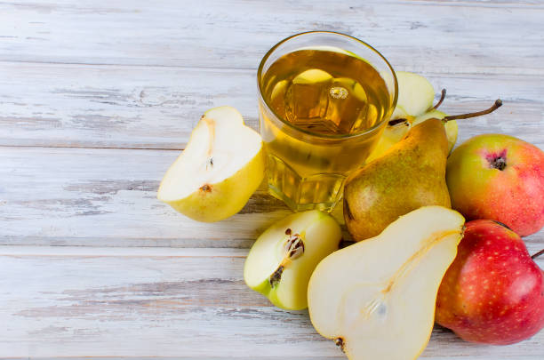 istock juice in a glass and a ripe apples and pears on a wooden table 867775662