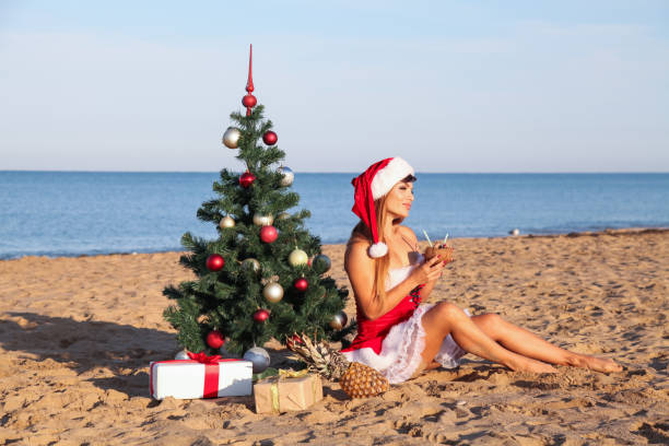 istock girl on beach sits Christmas tree resort cocktail 867782838
