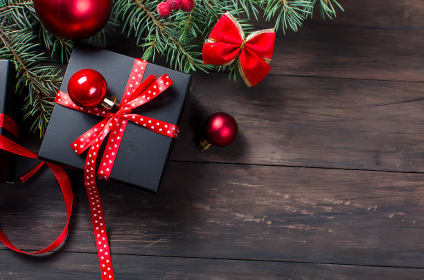 istock Black christmas  gift  box with red ribbon and fir branches 867784850