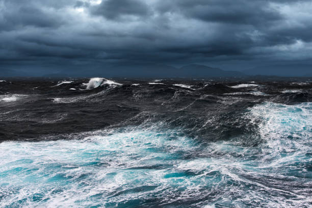 Storming Seas Storming Seas and Mountains in the Horizon storming stock pictures, royalty-free photos & images