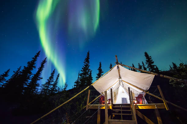 Aurora Borealis glowing green and pink over large canvas luxury camping tent in Alaska Aurora Borealis glowing green and pink over large canvas luxury camping tent in Alaska anchorage alaska photos stock pictures, royalty-free photos & images