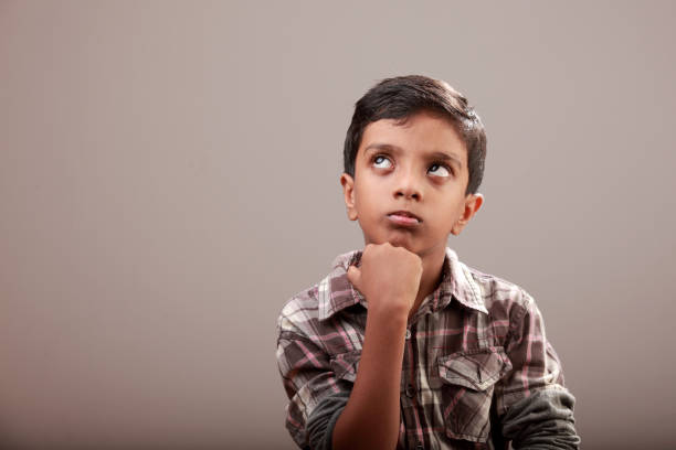 istock Portrait of a little boy looking up with a doubtful face 867826620